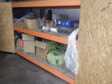un homme debout à côté d'une étagère remplie de cartons et encore de cartons