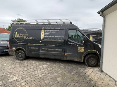 a black van parked in a parking lot next to a building