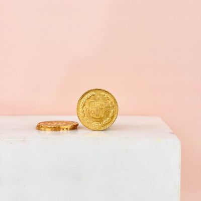 a gold coin sitting on top of a marble block