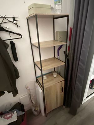 a shelf with clothes on it in the corner of a room