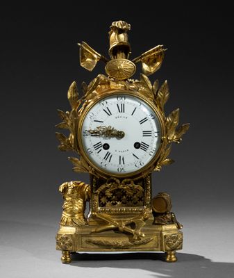 une horloge en or surmontée d'un oiseau