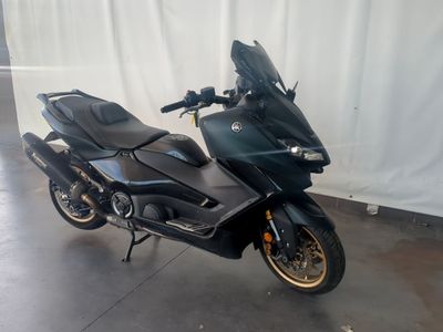 une moto noire garée dans un garage fermé par un rideau blanc