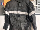 une veste en cuir noir à rayures blanches suspendue à un cintre