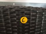 a black wicker chair with a yellow sticker on it