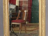 un miroir avec un cadre doré sur le mur