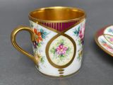 a cup and saucer sitting on a table next to each other