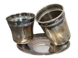 two silver cups on a silver plate on a white background
