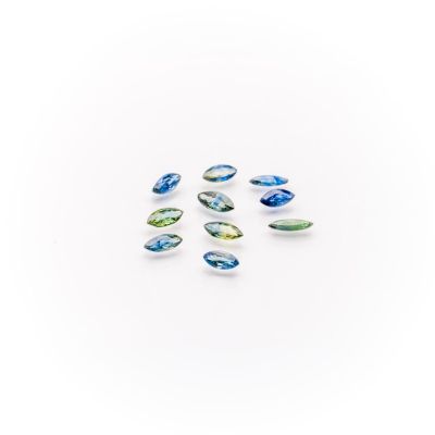 a group of blue and green glass beads on a white surface