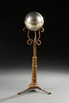 un globe en laiton ancien posé sur un trépied, avec un fond noir