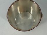 a silver bowl with a handle on a white table