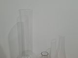 trois vases en verre posés les uns à côté des autres sur une étagère