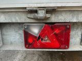 the rear end of a truck with a red triangle on it ' s bumper