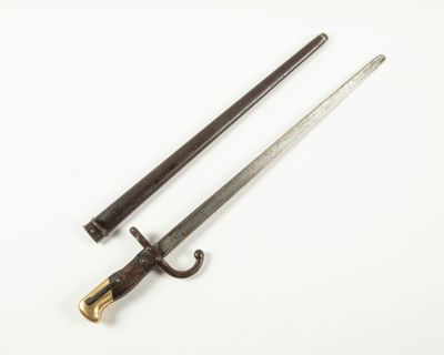 une vieille épée avec un manche en bois sur une surface blanche