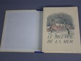 an open book with a picture of a house in the background