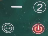 a close up of a button on a green button board