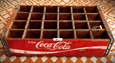 une vieille caisse en bois de Coca-Cola posée sur une nappe à motifs