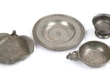 trois objets en pewter et un bol posés sur un plan de travail blanc