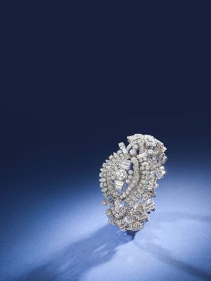 un gros plan d'une bague en diamant posée sur une surface bleue