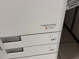 the printer is sitting on the tiled floor in the room