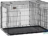 une cage pour chien noire dont la porte est ouverte, avec un tapis noir posé en dessous