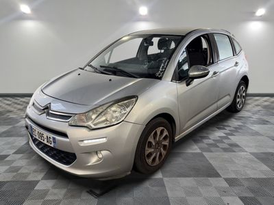 la petite voiture argentée est garée sur un sol en damier