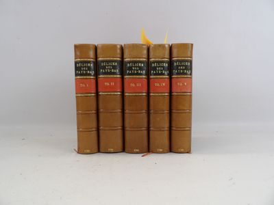 cinq livres sont empilés les uns sur les autres sur une surface blanche