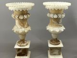 paire de vases en marbre sculpté sur socles, sur fond gris