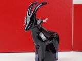 a black goat figurine sitting on a white table
