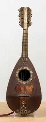 un objet en forme de guitare posé sur une table, muni d'un cordon