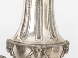 un vase en argent surmonté d'un oiseau