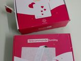 two boxes with a white and pink design on them sitting on a table