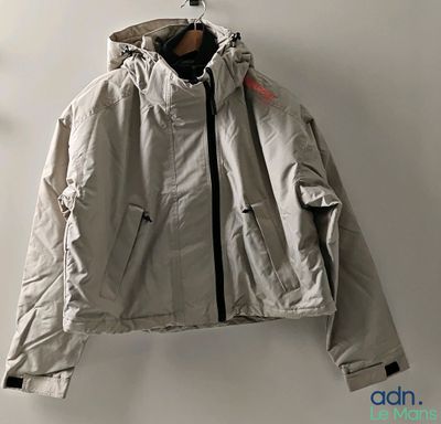 the jacket is hanging on a hanger on the wall
