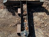 a broken train track laying on the ground in the woods
