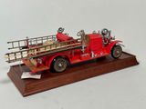 a model of a red fire truck on a wooden base