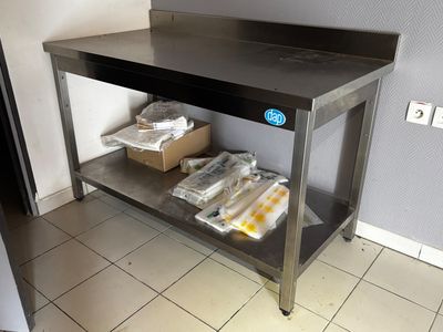 une table en métal sur laquelle sont posés plusieurs sacs de nourriture