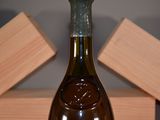 a bottle of wine sitting on a table next to a block of wood