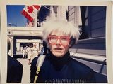 une photo Polaroid d'un homme aux cheveux blancs et portant des lunettes