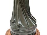 statue of a woman holding a glass of wine on a wooden base