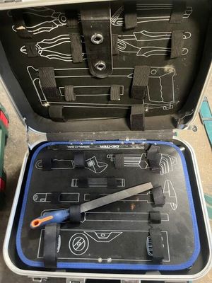 une valise contenant des outils, posée par terre