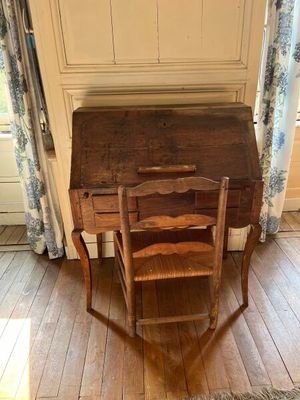 un petit bureau en bois avec une chaise devant