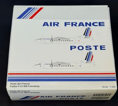 une boîte d'avions « Air France Poste » posée sur une surface noire