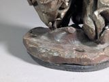 a statue of a man and a woman sitting on a rock