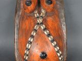 une photo d'une sculpture en bois représentant un hibou, posée sur un socle