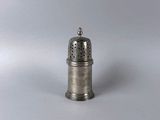 silver plated salt and pepper shaker on a plain surface