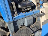 a blue tractor that is parked in the dirt