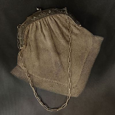 un gros plan d'un sac à main posé sur une table, avec une chaîne