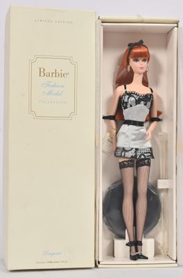 poupée Barbie dans une boîte, vêtue d'une robe noire et blanche et de bas