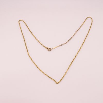 un collier à chaîne en or orné d'une seule perle sur fond blanc