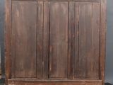 an old wooden cabinet with three doors and a drawer underneath it