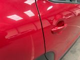 a close up of a red car with a broken door handle